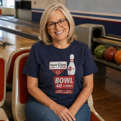 Woman sitting at a bowling alley wearing 4 Seasons Bowl Union NJ retro t-shirt