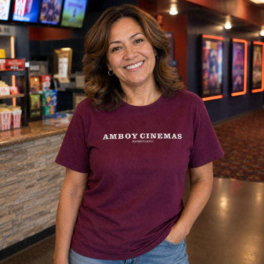 Woman holding popcorn in a movie theater lobby wearing Amboy Cinemas Sayreville NJ t-shirt