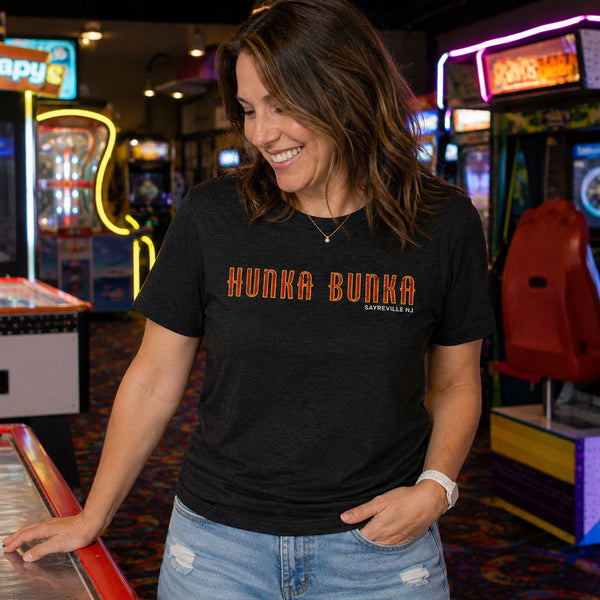 Woman in an arcade with neon lights wearing Hunka Bunka Sayreville NJ retro t-shirt
