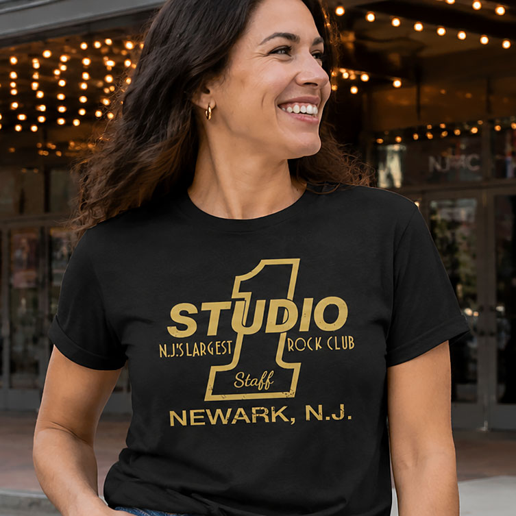 Woman smiling wearing gold Studio 1 Newark NJ rock club t-shirt